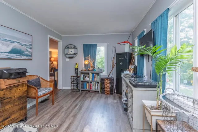 a living room with furniture a potted plant and a large window