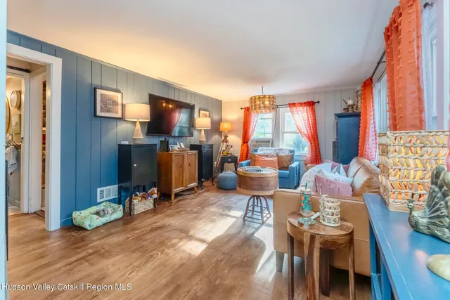 a living room with furniture a flat screen tv and a large window
