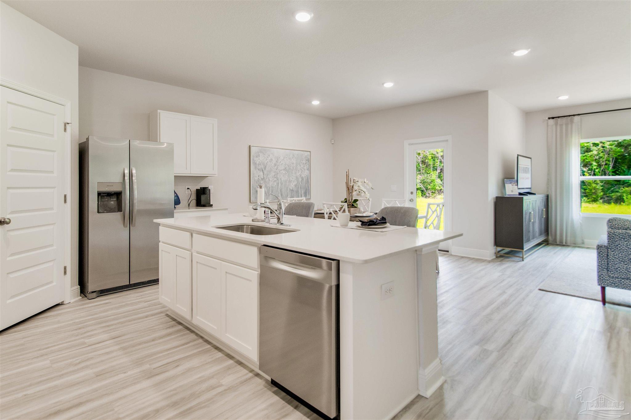 4753 Redhead Court Pace, FL 32571 - Photo 14 of 44 a kitchen with a sink cabinets stainless steel appliances and windows