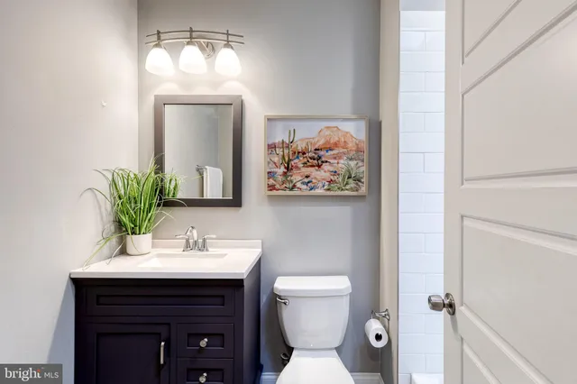 a bathroom with a toilet a sink and mirror