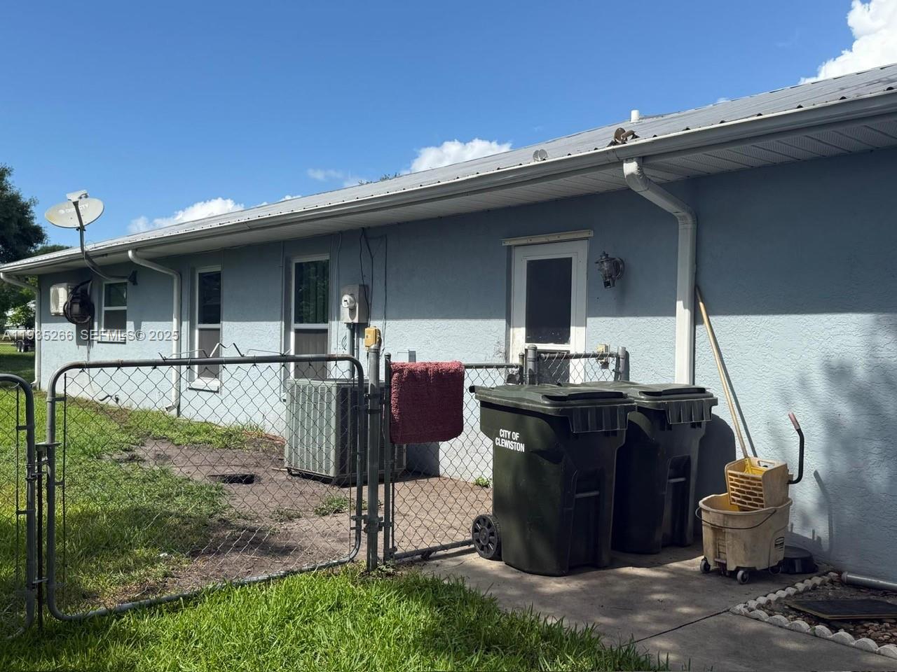 1046 Bayberry Loop Clewiston, FL 33440 - Photo 30 of 32 a view of a patio with table and chairs potted plants with wooden fence