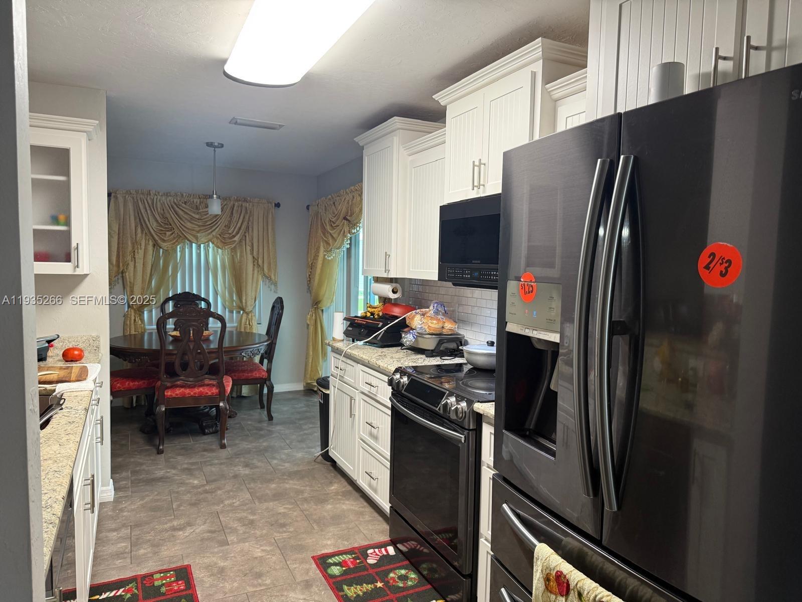 1046 Bayberry Loop Clewiston, FL 33440 - Photo 6 of 32 a kitchen with stainless steel appliances granite countertop a refrigerator stove and a sink