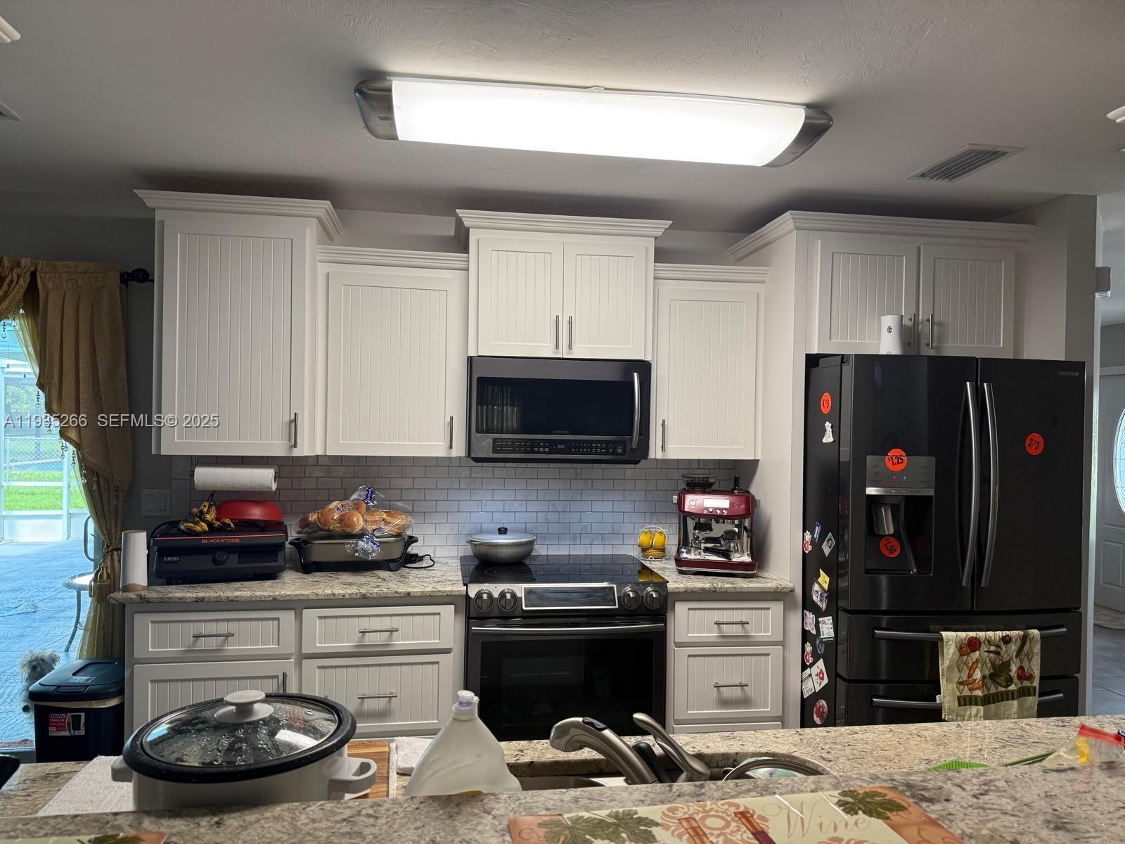 1046 Bayberry Loop Clewiston, FL 33440 - Photo 7 of 32 a kitchen with a stove and a refrigerator