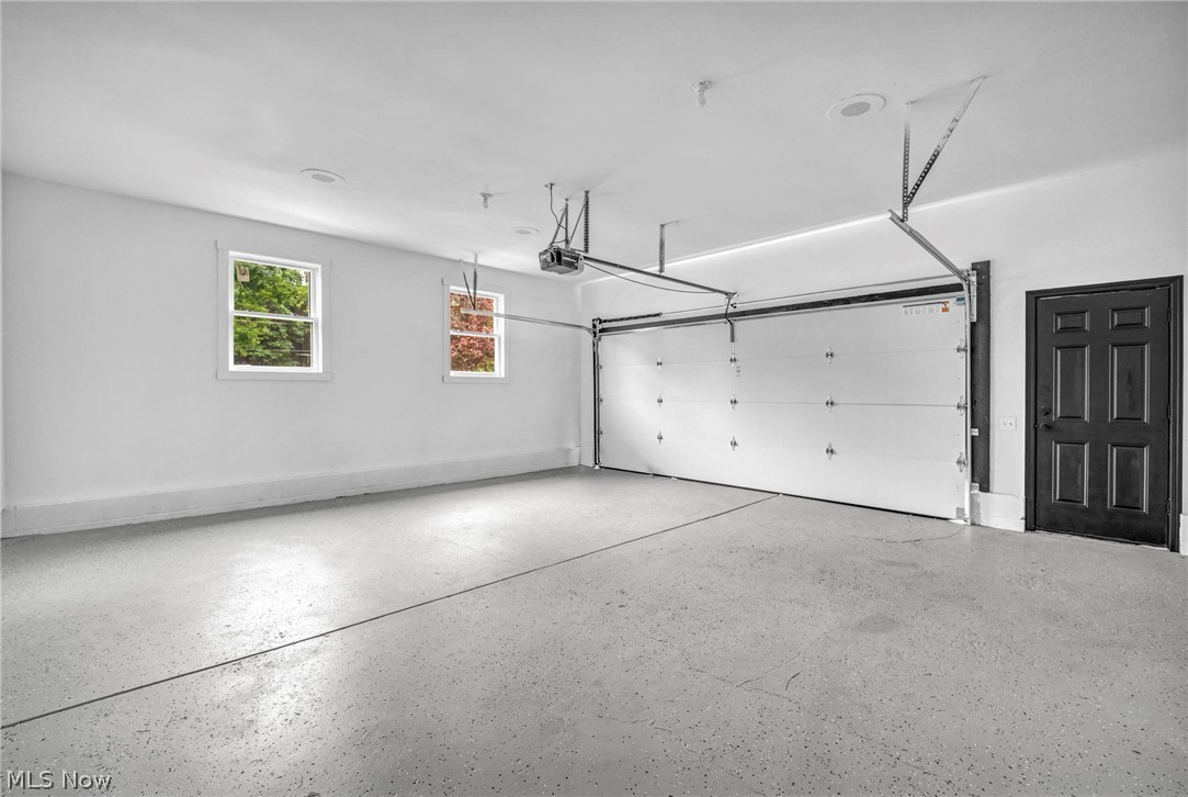 3759 Herr Fieldhouse Road Southington, OH 44470 - Photo 27 of 35 Spacious garage featuring an epoxy-coated concrete floor, two windows, recessed lighting, a paneled door, and an overhead garage door with opener