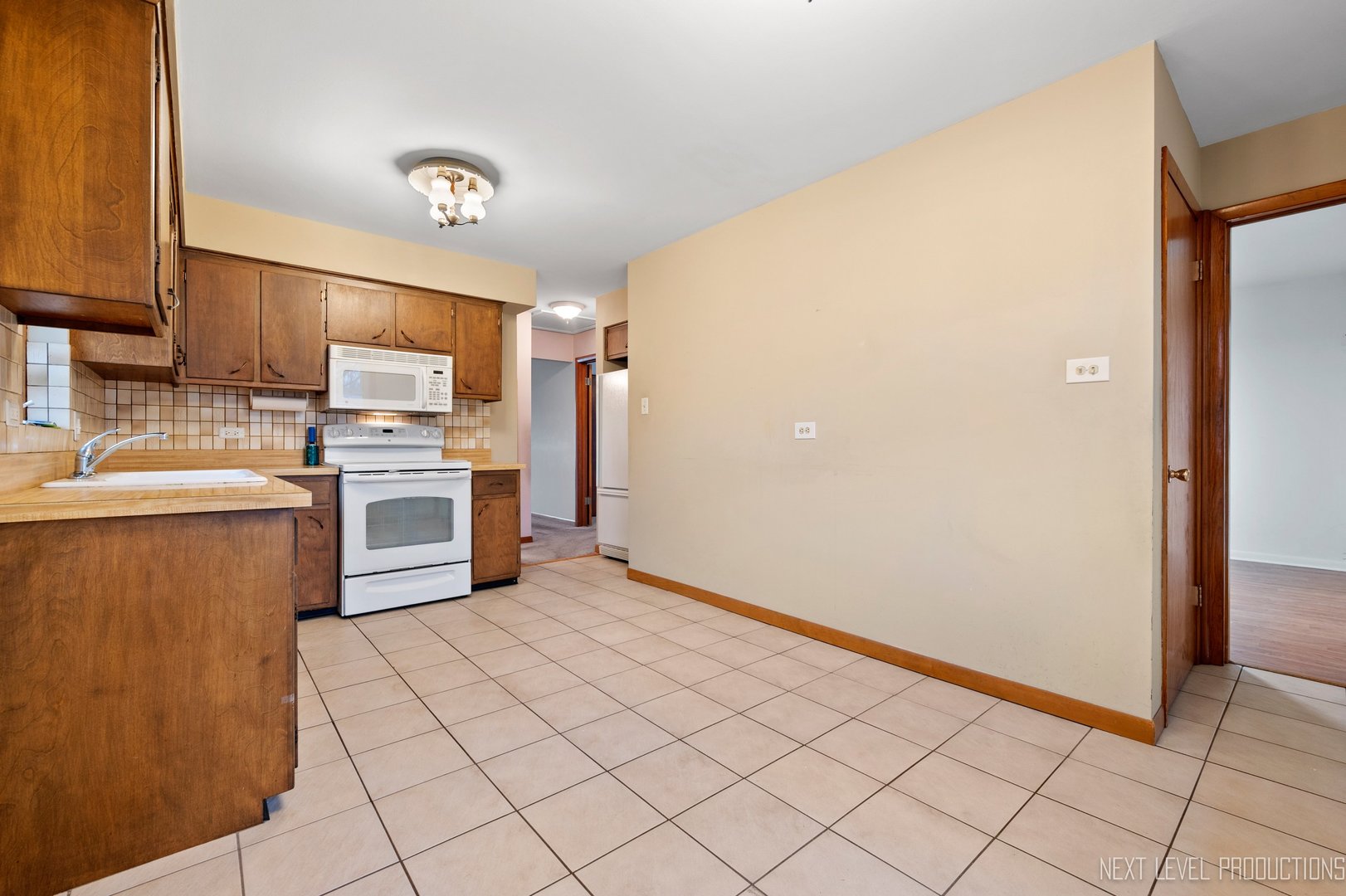 10336 Leslie Lane Chicago Ridge, IL 60415 - Photo 11 of 28 a kitchen with a sink a stove top oven and cabinets
