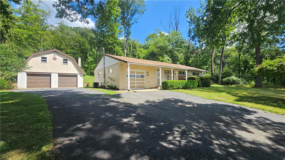 2529 Ringhoffer Road Hellertown, PA 18055 - Photo 1 of 33 A well-maintained home awaits, nestled amidst verdant trees and boasting a detached garage.
