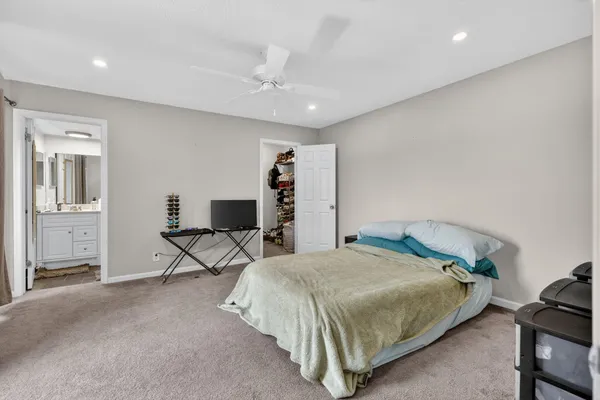 a bedroom with a bed a table and painting on the wall