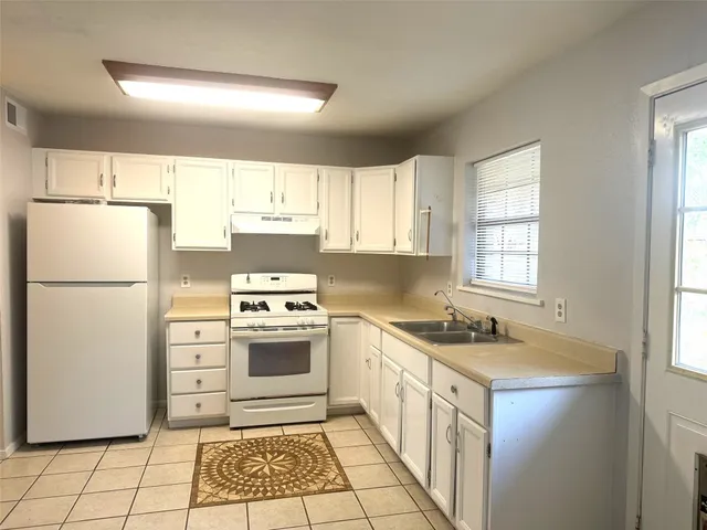 a kitchen with a stove a refrigerator and a sink