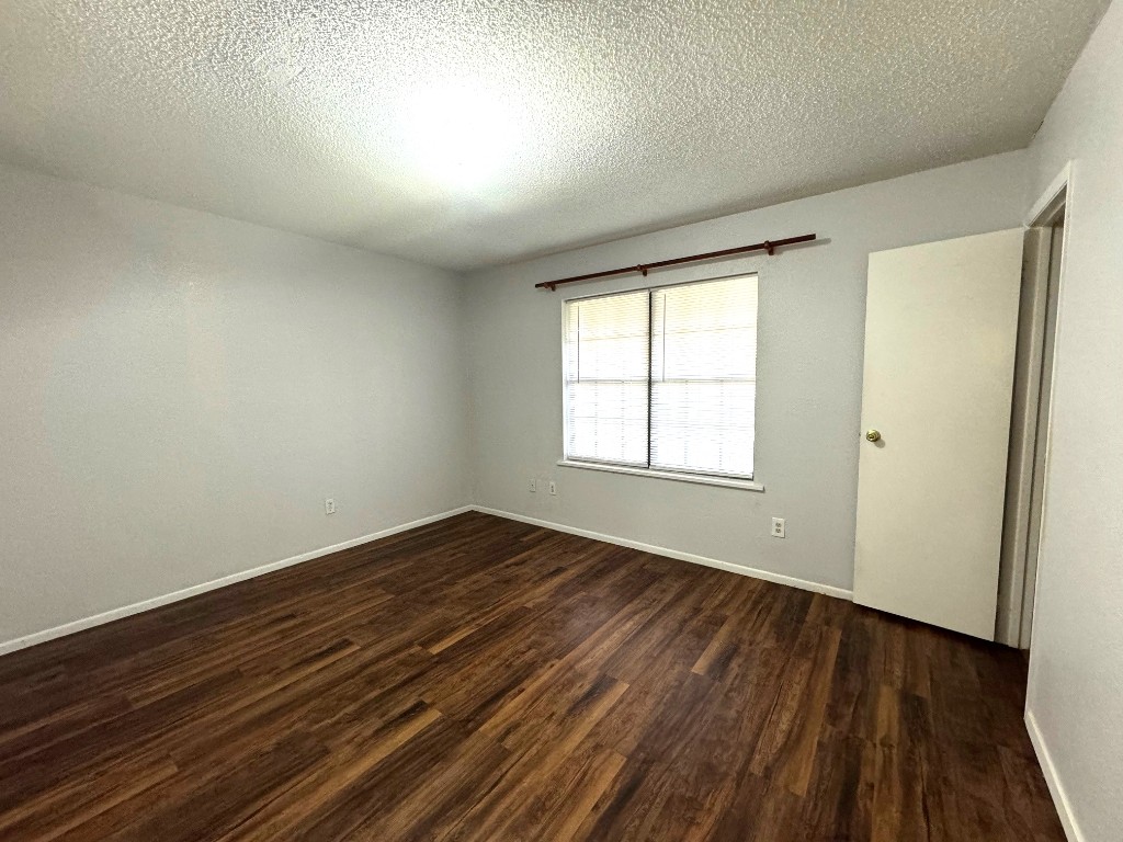 1307 Center Street Lockhart, TX 78644 - Photo 9 of 14 an empty room with wooden floor and windows