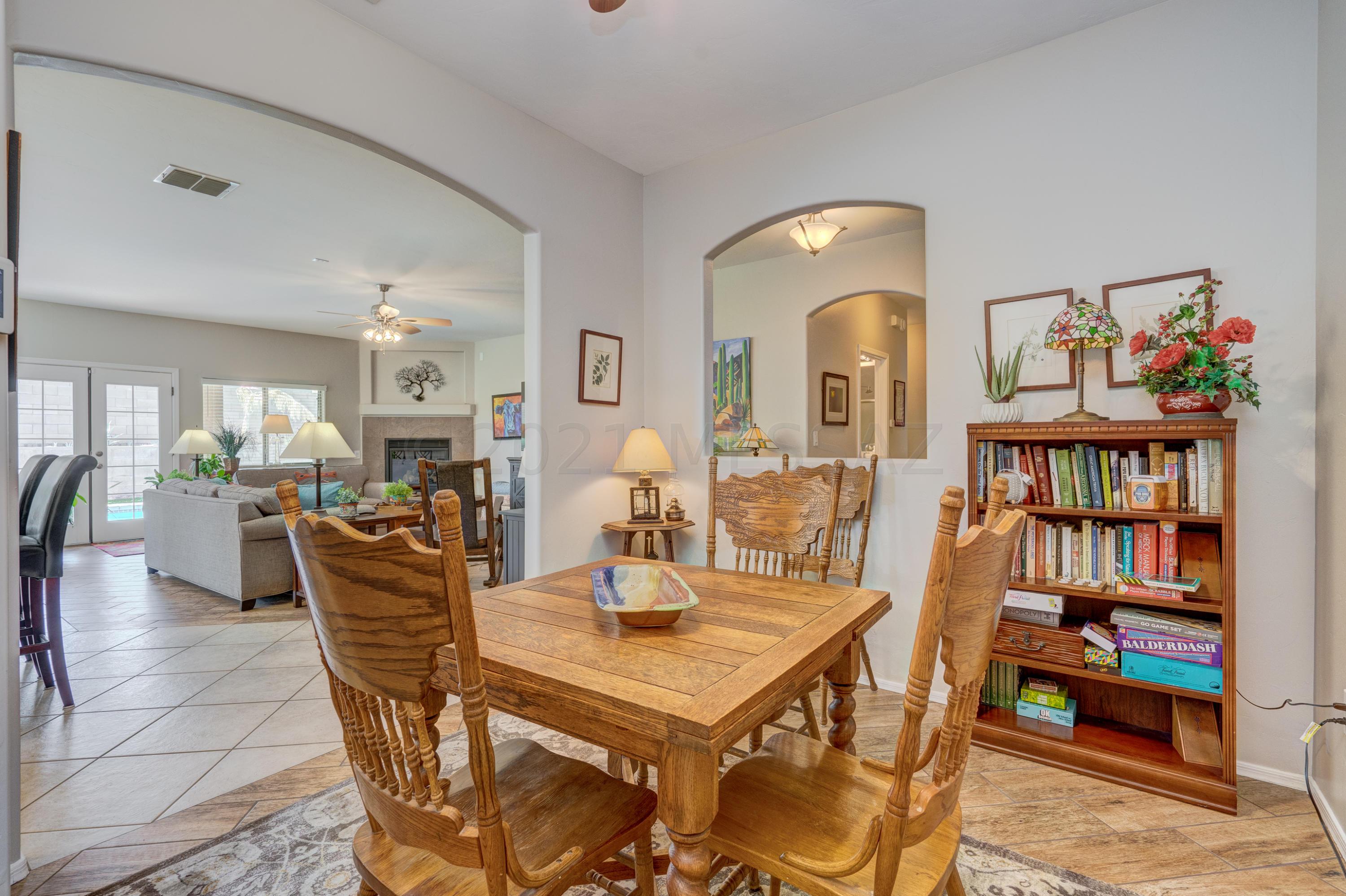 3639 East Northern Dancer Road Tucson, AZ 85739 - Photo 13 of 48 a dining room with furniture and a book shelf