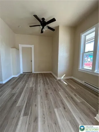 a view of a big room with wooden floor closet and windows