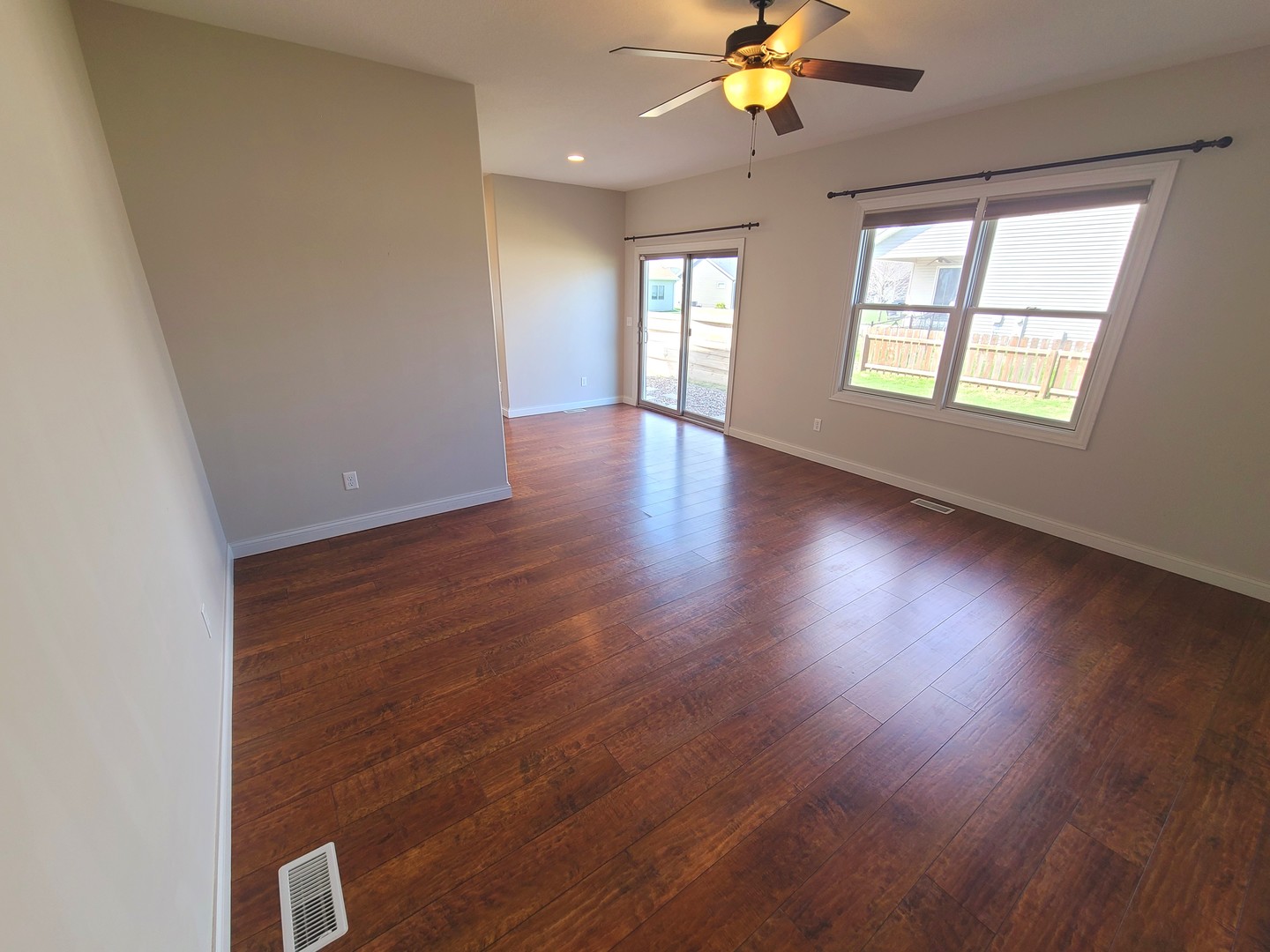 790 Muirfield Circle Eldridge, IA 52748 - Photo 13 of 36 an empty room with wooden floor chandelier fan and windows