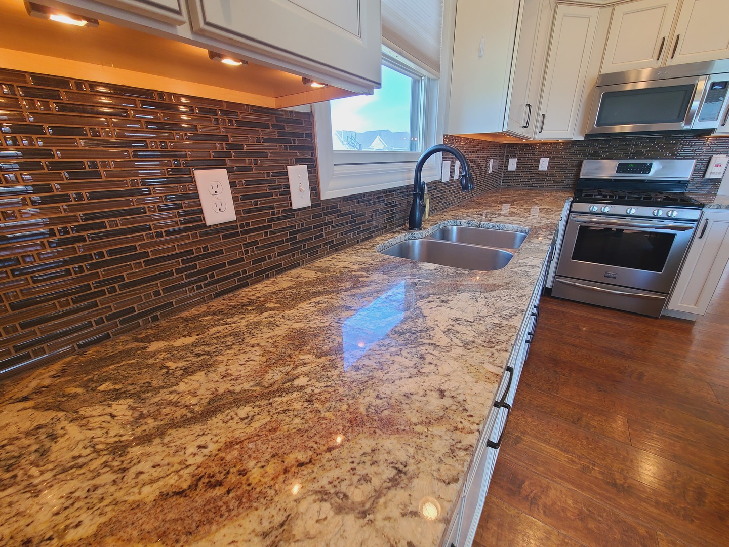 790 Muirfield Circle Eldridge, IA 52748 - Photo 10 of 36 a kitchen with granite countertop a stove a sink and a microwave
