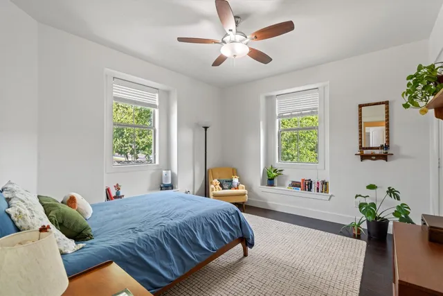 a bedroom with a bed ceiling fan and a window
