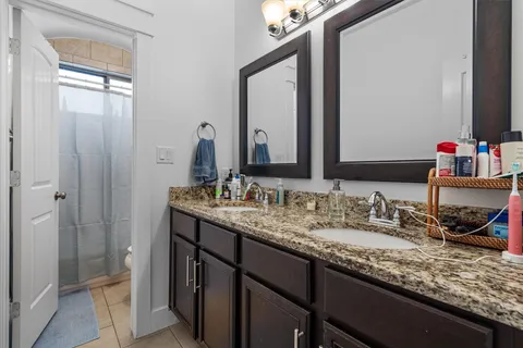a bathroom with a granite countertop sink and a mirror