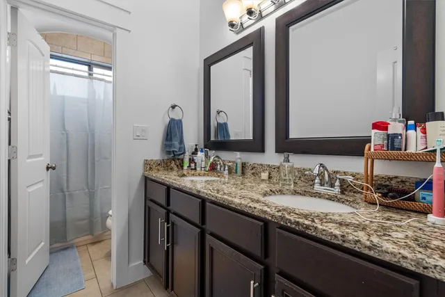 a bathroom with a granite countertop sink and a mirror