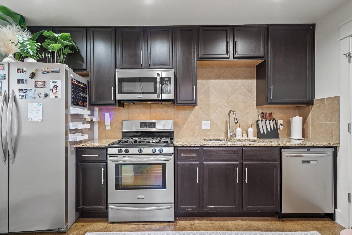 500 West 55th 1/2 Street, Unit A AND B Austin, TX 78751 - Photo 22 of 32 a kitchen with granite countertop a refrigerator stove and cabinets