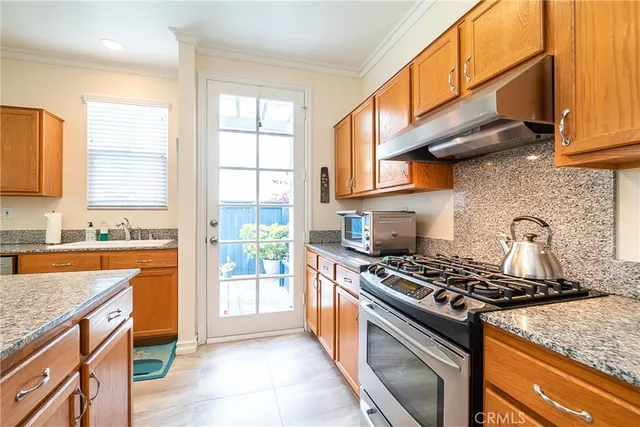 a kitchen with stainless steel appliances granite countertop a stove a sink and a microwave