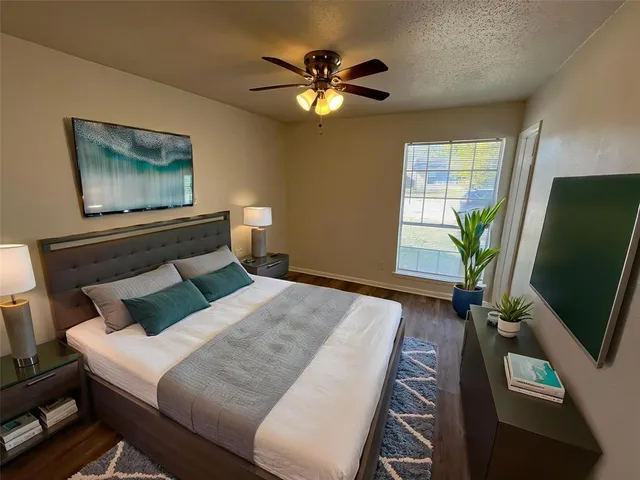 a bedroom with a bed window and a flat screen tv