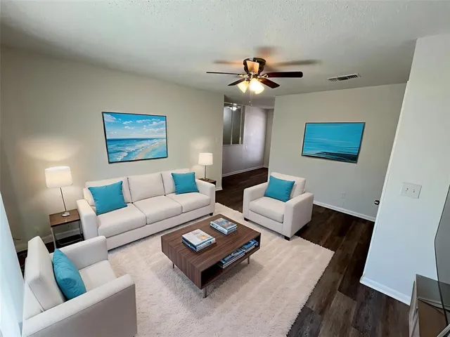 a living room with furniture and a wooden floor