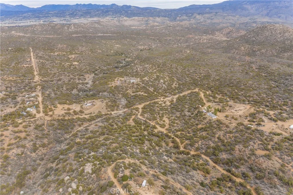69 Rim Rock Road Anza, CA 92539 - Photo 1 of 14 a view of a dry yard with mountains in the background