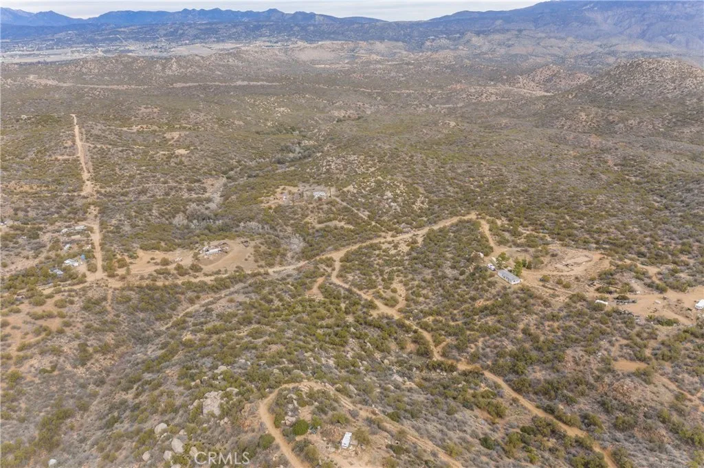 a view of a dry yard with mountains in the background