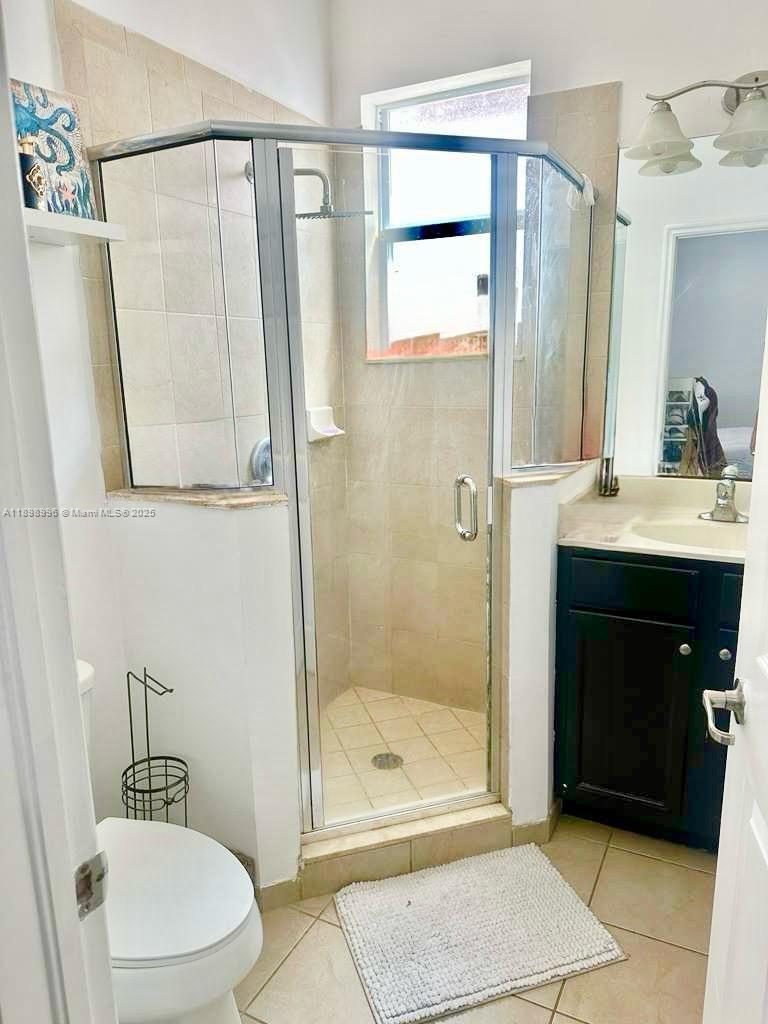 17154 Southwest 93rd Street, Unit STUDIO Miami, FL 33196 - Photo 3 of 9 a bathroom with a sink a toilet and shower