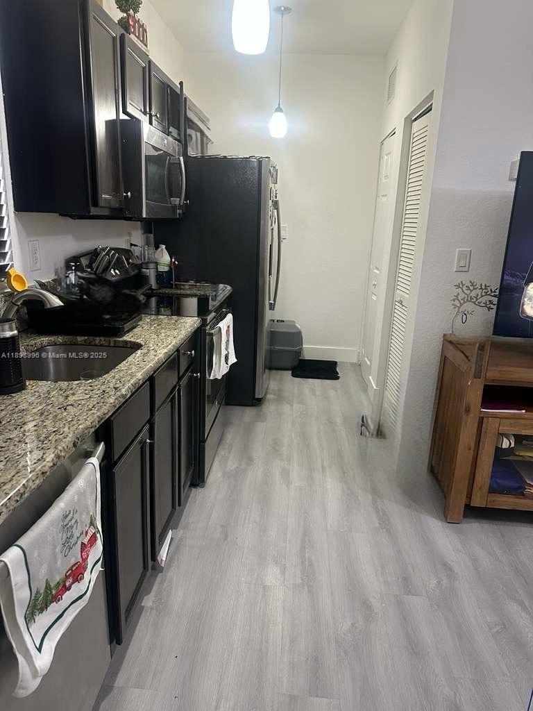 17154 Southwest 93rd Street, Unit STUDIO Miami, FL 33196 - Photo 4 of 9 a kitchen with granite countertop a sink stove and refrigerator