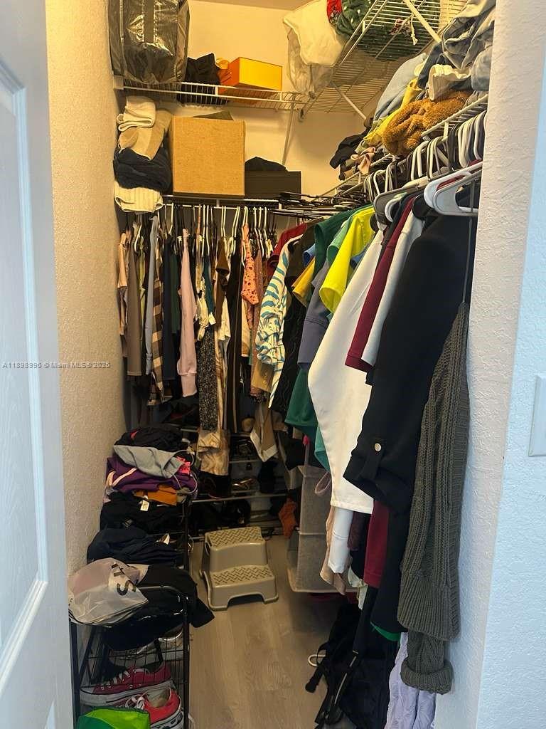 17154 Southwest 93rd Street, Unit STUDIO Miami, FL 33196 - Photo 6 of 9 a view of walk in closet with clothes and shoes