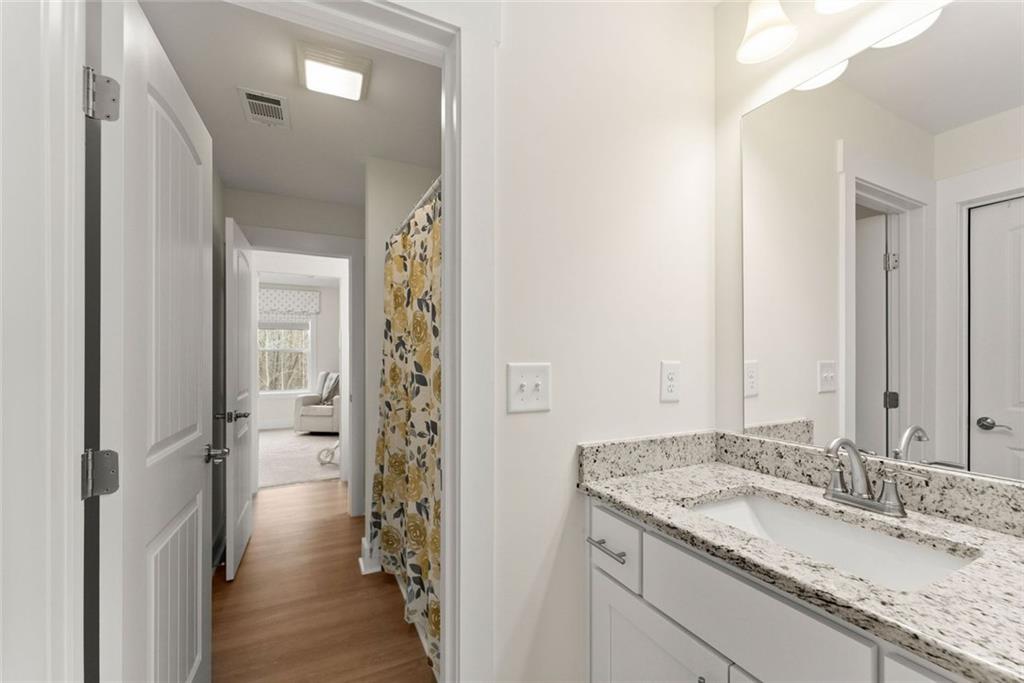6998 Britt Gailey Road Clermont, GA 30527 - Photo 43 of 92 a bathroom with a granite countertop sink and a mirror