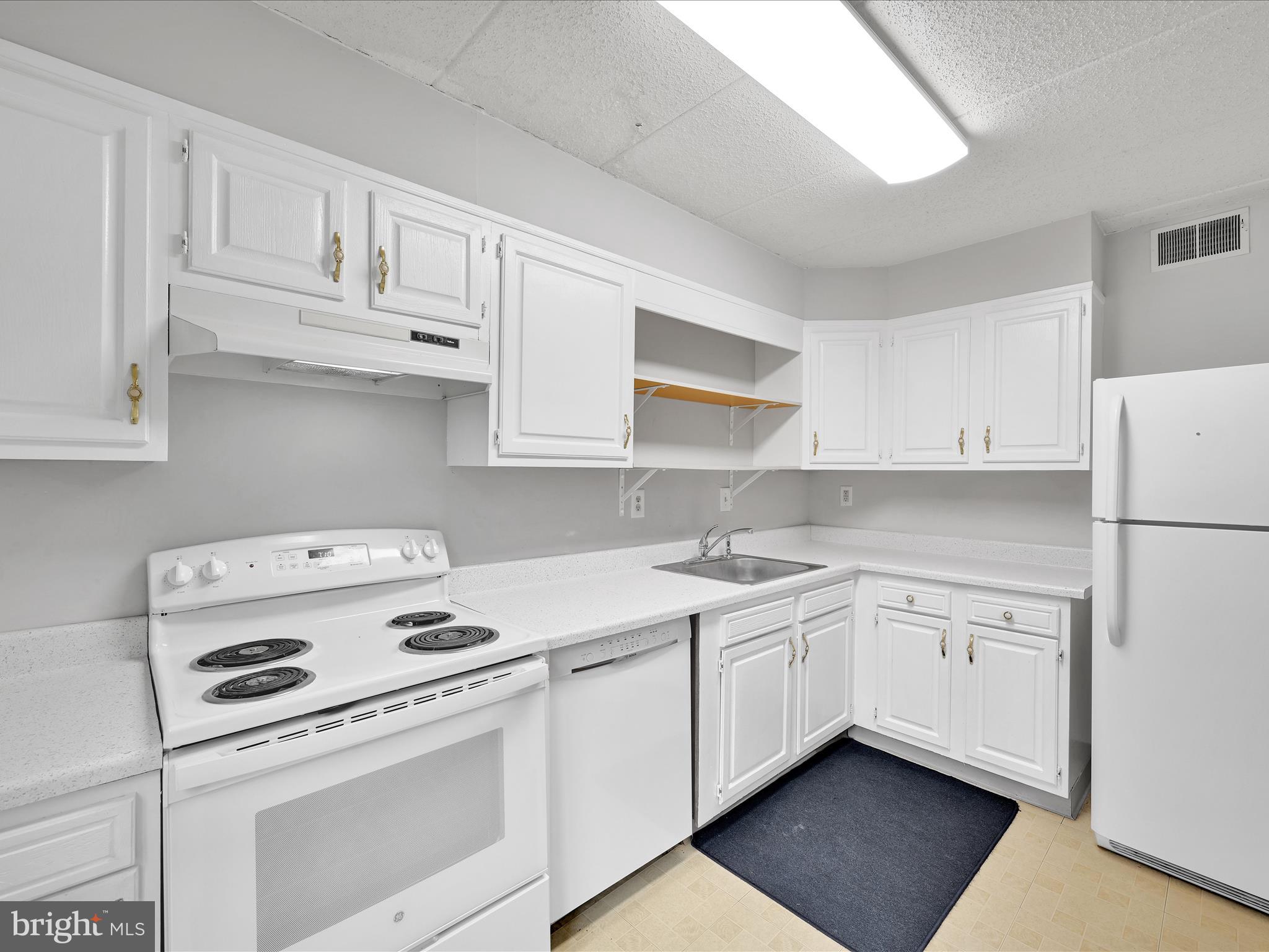 411 Conestoga Road, Unit 33 Devon, PA 19333 - Photo 8 of 23 a kitchen with white cabinets and white appliances