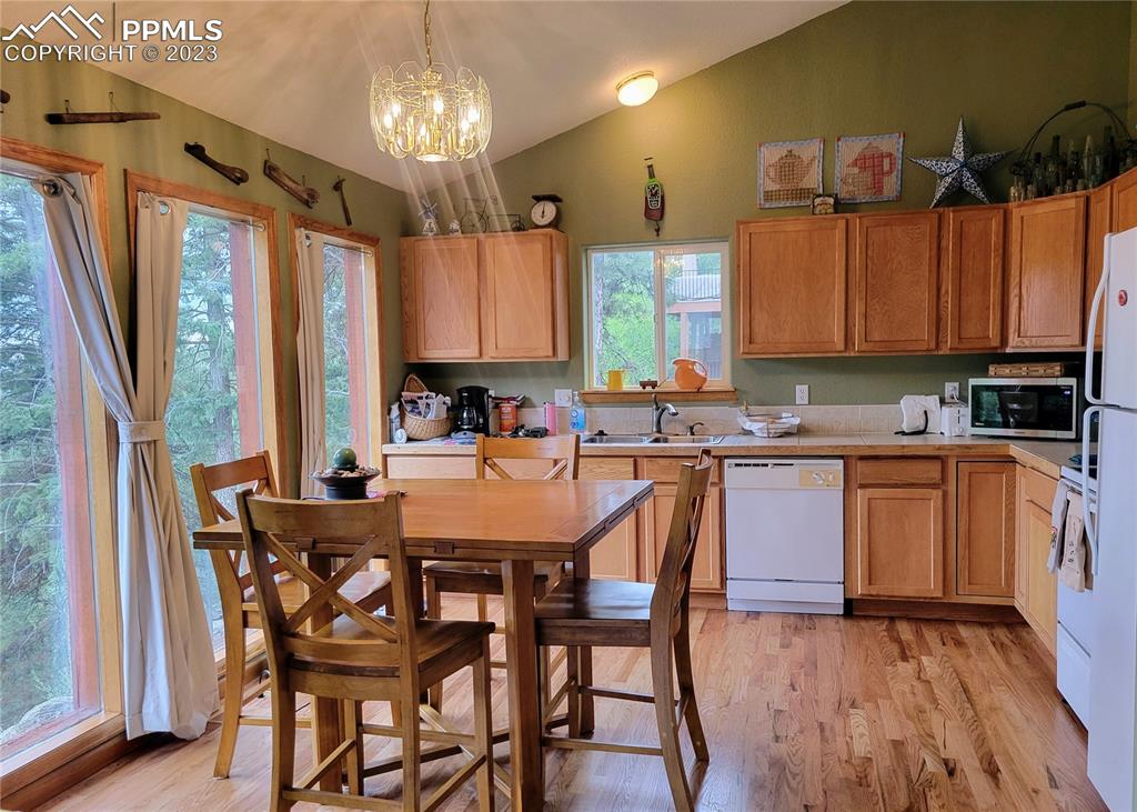 33348 Persistence Avenue Pine, CO 80470 - Photo 16 of 39 a kitchen with a dining table chairs sink and cabinets