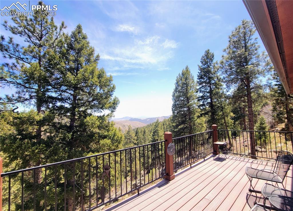 33348 Persistence Avenue Pine, CO 80470 - Photo 34 of 39 a view of a balcony with wooden floor and trees