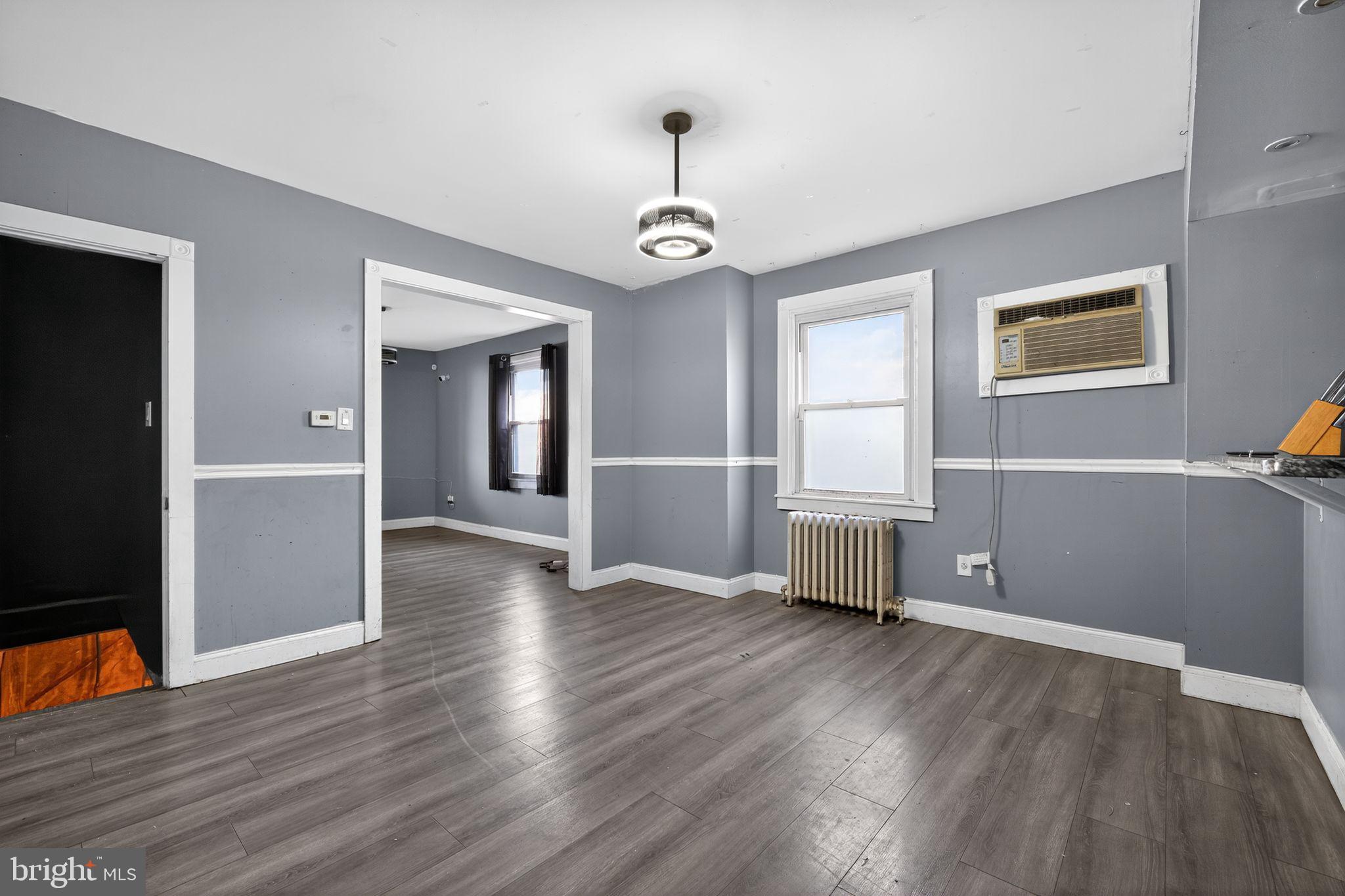 82 Marple Avenue Clifton Heights, PA 19018 - Photo 11 of 30 an empty room with wooden floor chandelier and windows