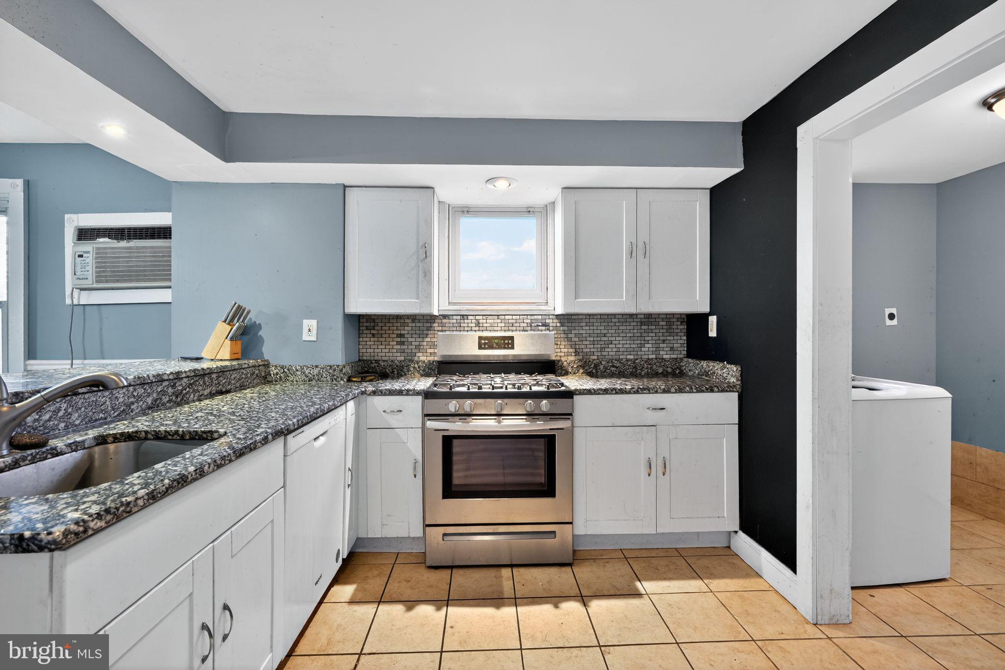 82 Marple Avenue Clifton Heights, PA 19018 - Photo 16 of 30 a kitchen with granite countertop a stove sink and cabinets