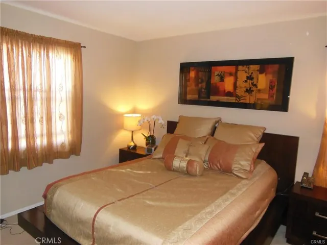 a bed sitting in a bedroom next to a window