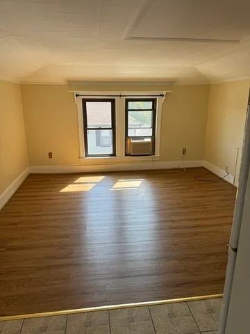 a view of a room with wooden floor and window