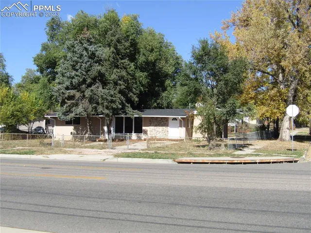 a white house with a tree in front of it
