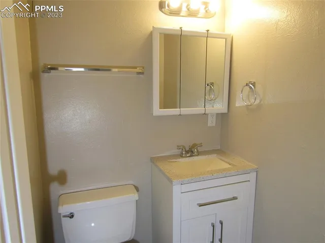 a bathroom with a sink a toilet and a mirror