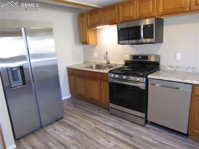 a kitchen with stainless steel appliances granite countertop a stove a microwave and a refrigerator