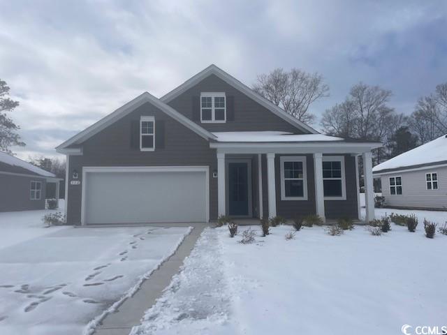 Craftsman-style home with a garage and a front law