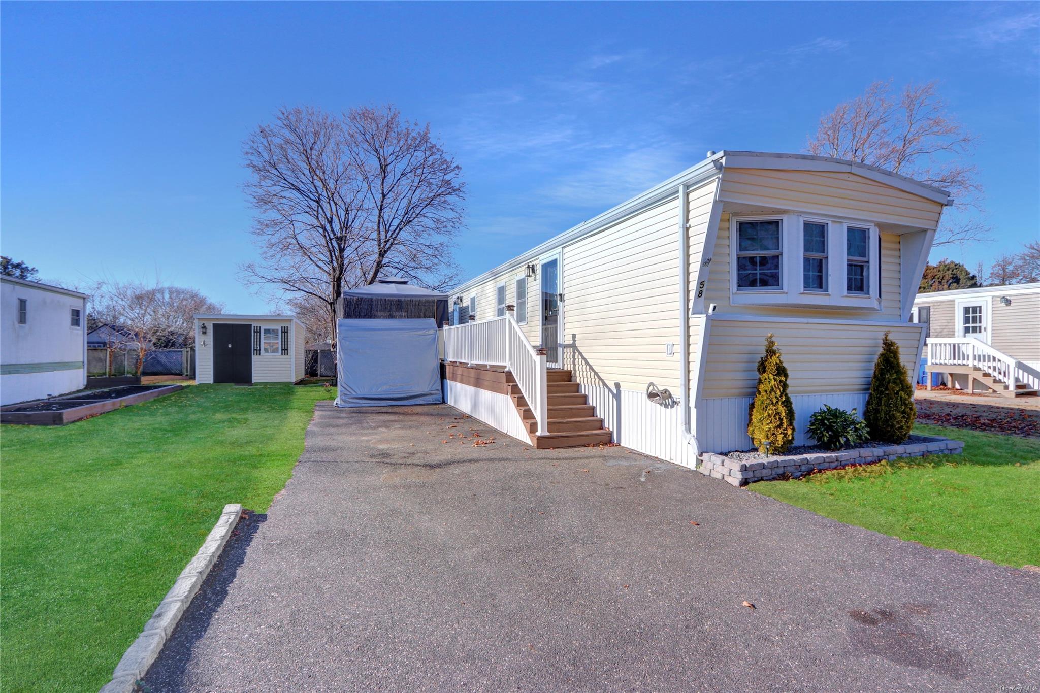 View of front of home featuring a front lawn and a shed
