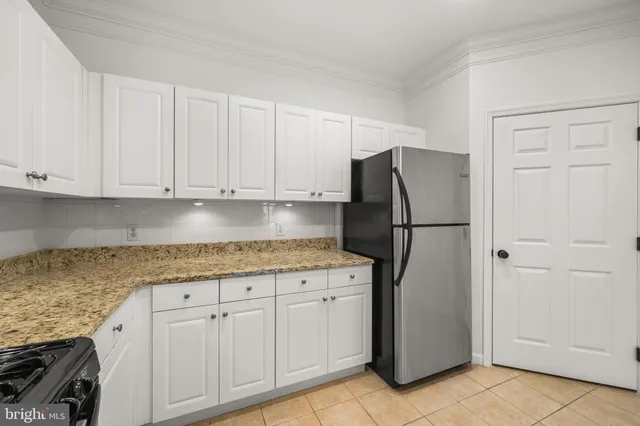 a kitchen with granite countertop cabinets and refrigerator