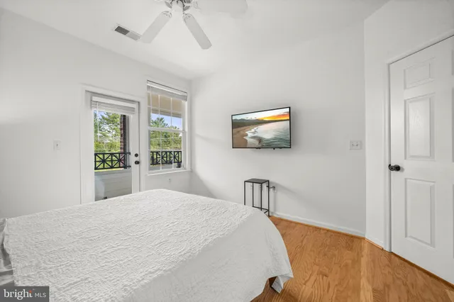 a bedroom with a bed and a flat tv screen on dresser