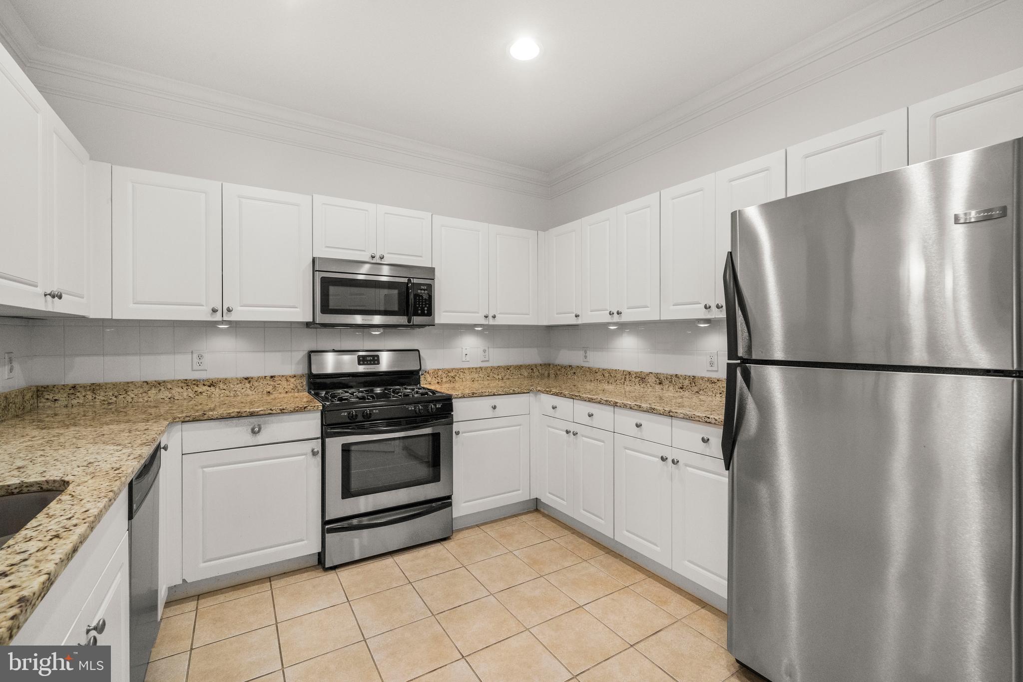 8 Granite Place, Unit 266 Gaithersburg, MD 20878 - Photo 8 of 36 a kitchen with granite countertop a refrigerator and a stove top oven