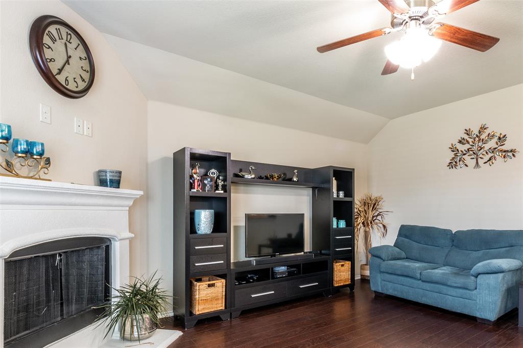 504 Rocky Pine Road McKinney, TX 75072 - Photo 14 of 36 Living room featuring hardwood / wood-style flooring, lofted ceiling, ceiling fan, and a fireplace with raised hearth