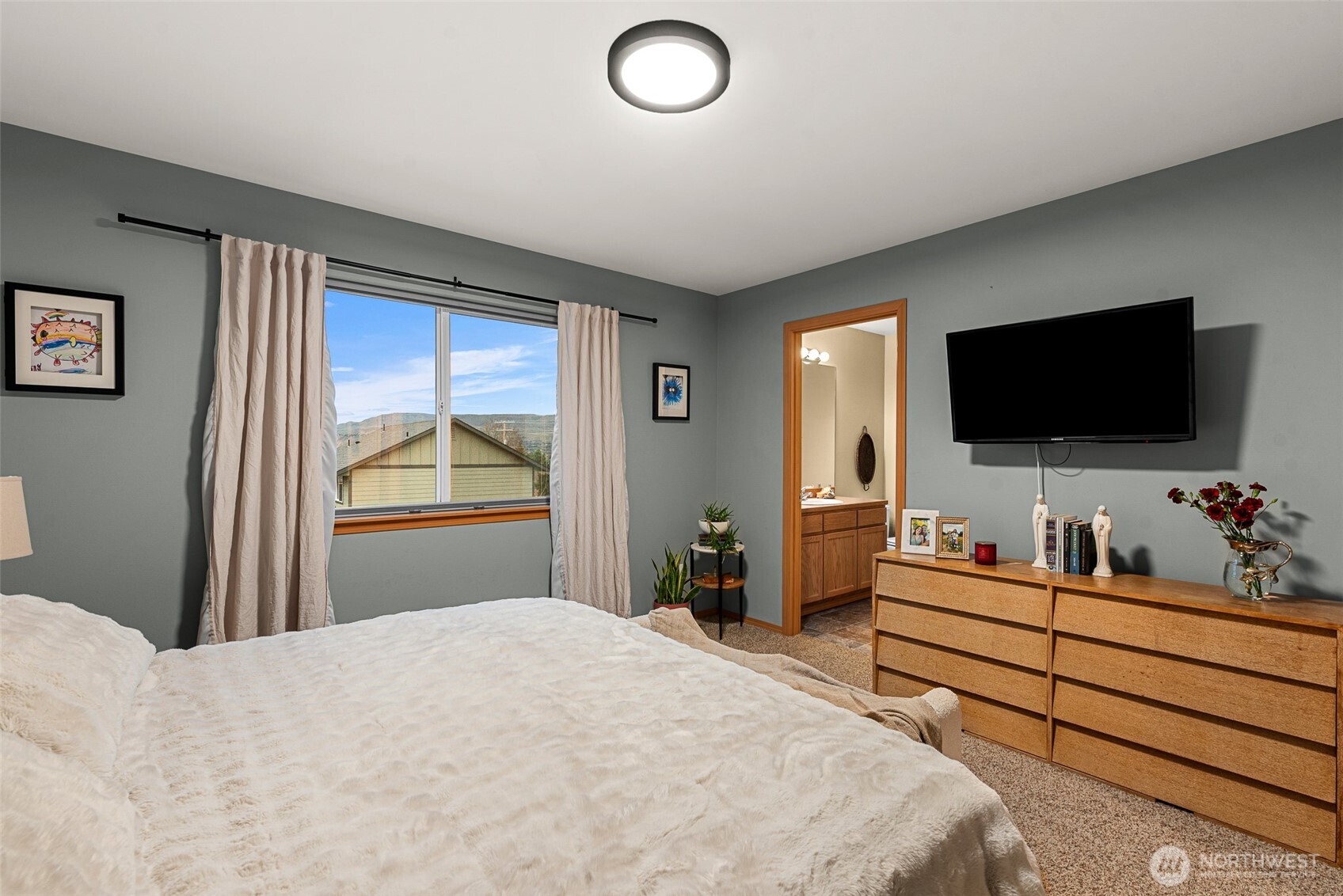 576 Saddle Rock Loop Wenatchee, WA 98801 - Photo 19 of 34 a bedroom with a bed and a flat screen tv