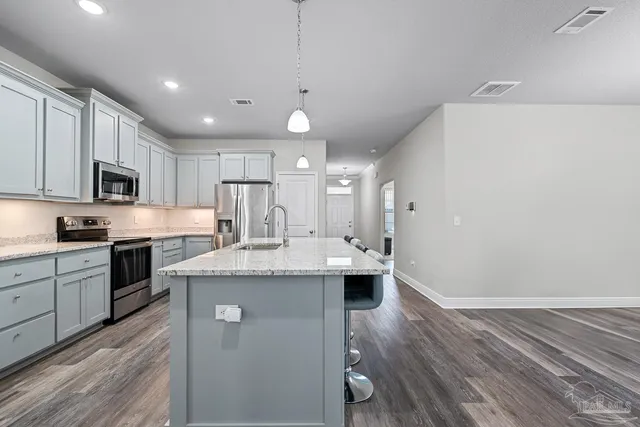a kitchen with kitchen island a sink stainless steel appliances and cabinets