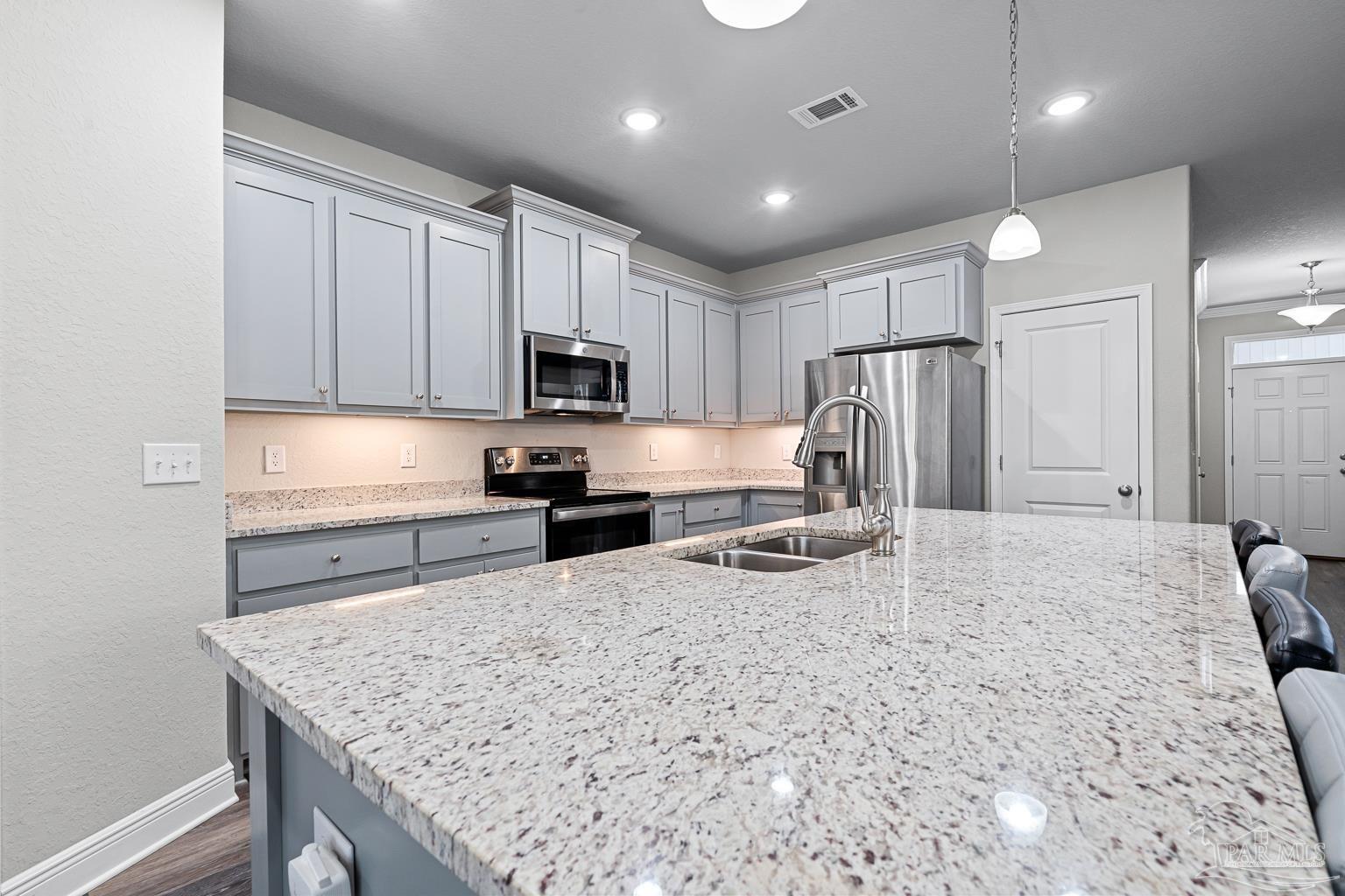 3838 Ranch Road Pace, FL 32571 - Photo 11 of 42 a kitchen with refrigerator cabinets and wooden floor
