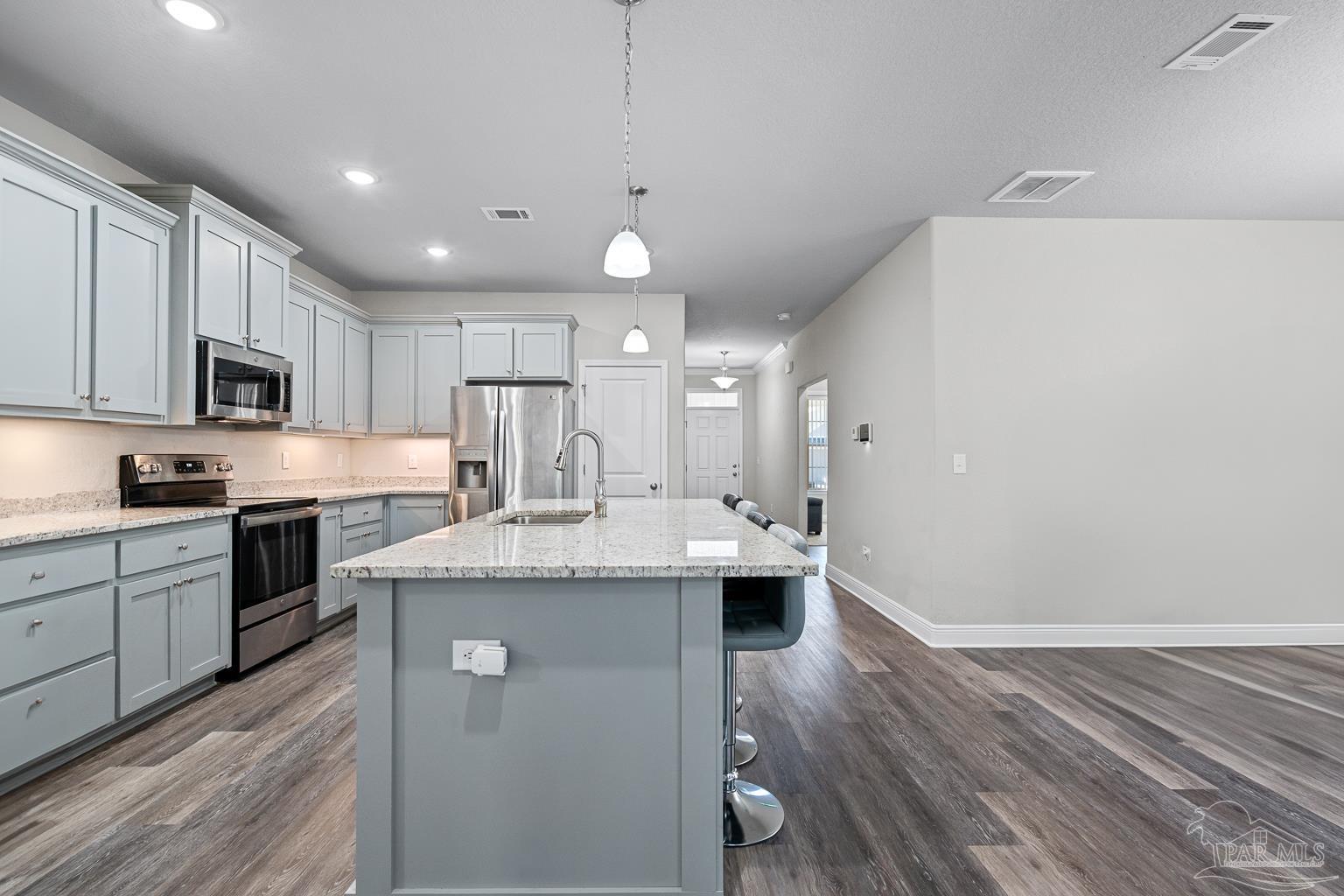 3838 Ranch Road Pace, FL 32571 - Photo 12 of 42 a kitchen with kitchen island a sink stainless steel appliances and cabinets